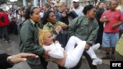 Agentes cubanos empujan, arrastran y suben a autobuses a Damas de Blanco. EFE/Rolando Pujol 