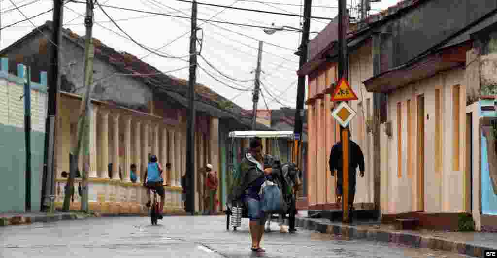 Una mujer camina por las calles de la ciudad de Baracoa, hoy, martes 04 de octubre, en Guantánamo (Cuba). El "extremadamente peligroso" huracán de categoría 4 Matthew.