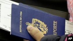 Un pasajero porta el pasaporte cubano. (AP Photo/Julio Cortez)