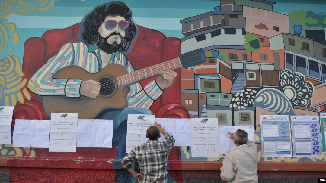 Votalntes chean las listas de candidatos en un colegio electoral de Caracas. 
