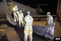 Fotografía facilitada de la llegada del médico cubano Félix Báez Sarría (2º izq), contagiado de ébola en Sierra Leona, al Aeropuerto Internacional de Ginebra (Suiza) en la noche del 20 de Noviembre de 2014.