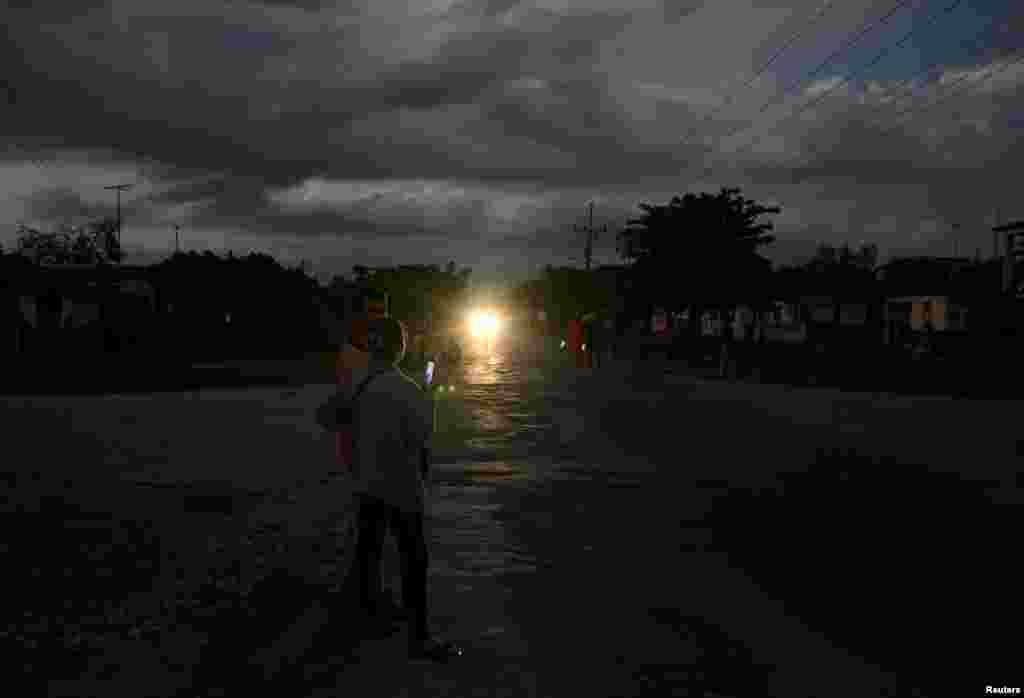 La gente se congrega en la calle en busca de servicio telefónico y de internet durante un apagón, en Palpite, Ciénaga de Zapata, Cuba, 7 de abril de 2026. REUTERS/Norlys Perez