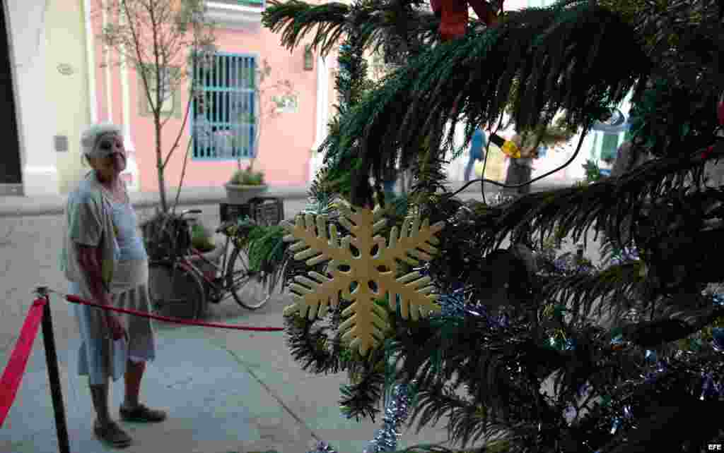  Una anciana observa un árbol de navidad en La Habana Vieja.