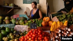 Una mujer vende vegetales y frutas en un mercado local en La Habana. 