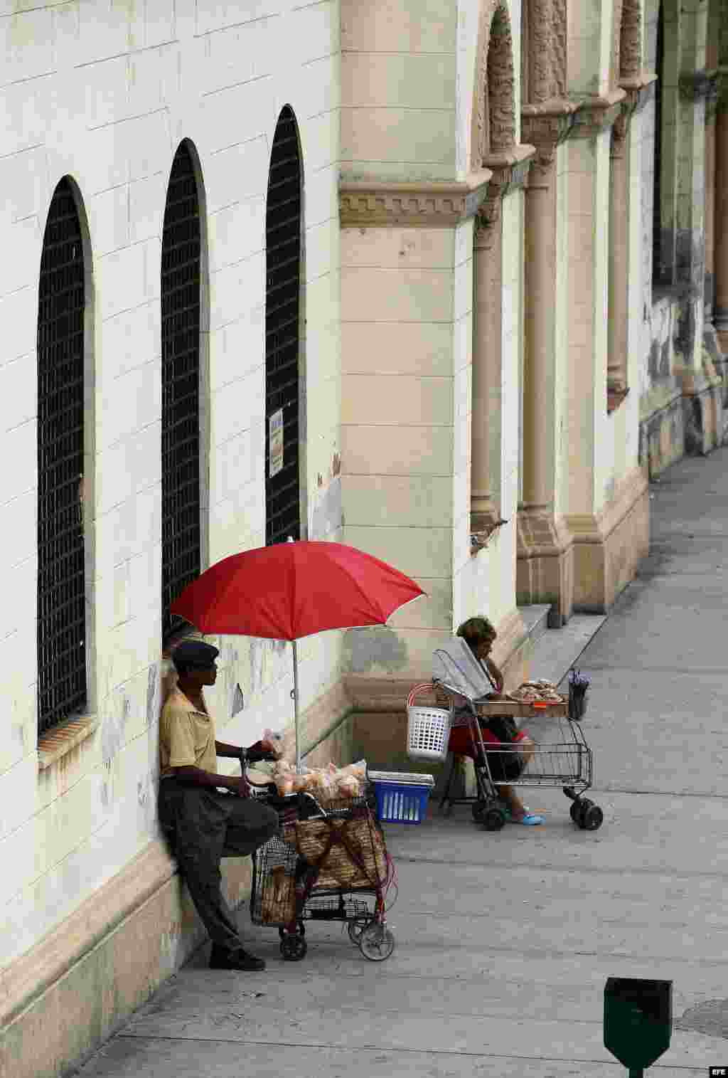 Dos vendedores ambulantes esperan la llegada de clientes en una céntrica calle de La Habana.