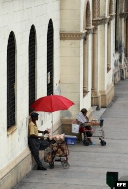 Dos vendedores ambulantes esperan la llegada de clientes en una céntrica calle de La Habana.