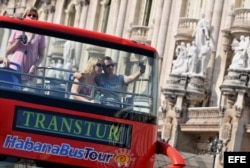 Una pareja de turistas se toma una foto en un bus en La Habana.