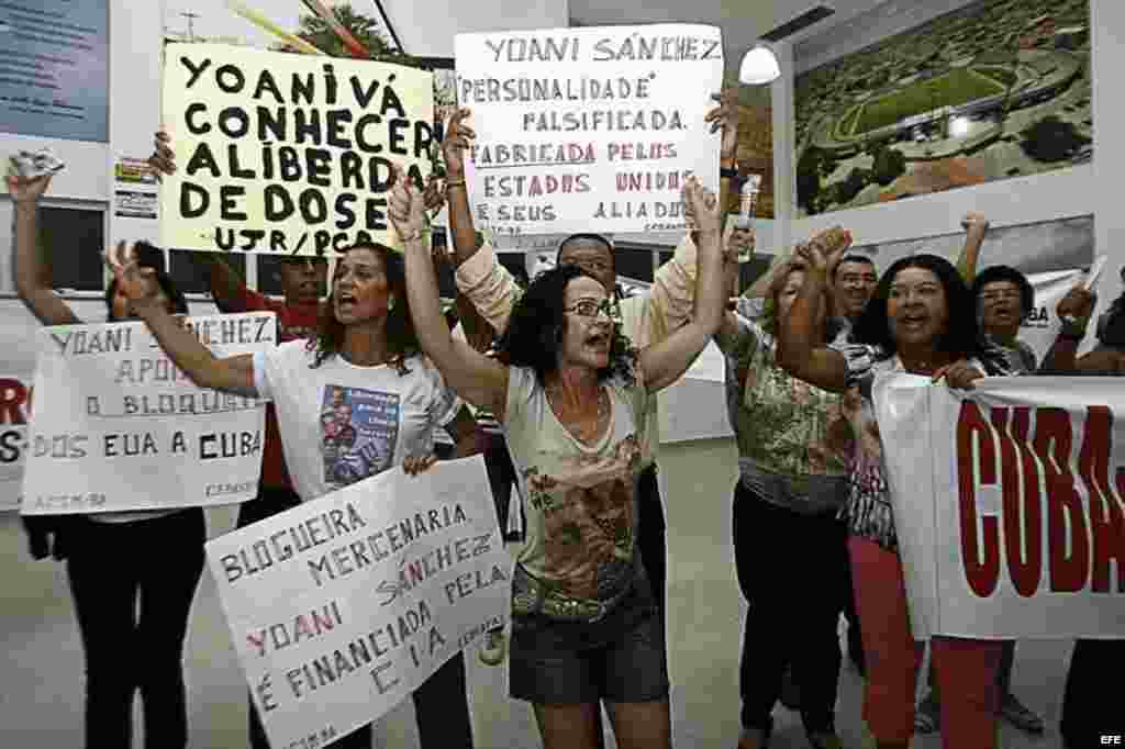 Simpatizantes del régimen cubano gritan consignas y muestran carteles durante un evento para la exhibición del documental "Conexión Cuba-Honduras", durante la visita de la cubana Yoani Sánchez.