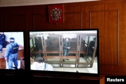 Encerrado en una cabina de cristal y rodeado de agentes armados es juzgado el periodista ruso Vadimir Kara-Murzael