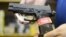 Un propietario de una armería muestra una pistola semiautomática Sig Sauer en su negocio.