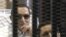Foto de archivo del expresidente egipcio, Hosni Mubarak (izq), mientras comparece desde una celda en la sala del tribunal a una sesión de su juicio en la Academia de la Policía en El Cairo