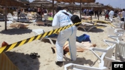 Un policía examina el cadáver de un turista muerto por un terrorista solitario en el balneario de Sousse, Tunez
