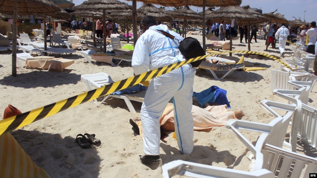 Un policía examina el cadáver de un turista muerto por un terrorista solitario en el balneario de Sousse, Tunez