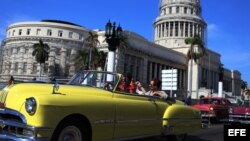 Dos turistas viajan en un viejo auto descapotable por una calle de La Habana Vieja. (Archivo)