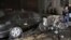 Fotografía cedida facilitada por la agencia siria de noticias SANA que muestra a unos policías sirios inspeccionando el lugar donde se ha registrado un atentado con coche bomba ante la sede del Ministerio del Interior sirio en Damasco, Siria. 