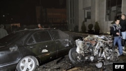 Fotografía cedida facilitada por la agencia siria de noticias SANA que muestra a unos policías sirios inspeccionando el lugar donde se ha registrado un atentado con coche bomba ante la sede del Ministerio del Interior sirio en Damasco, Siria. 
