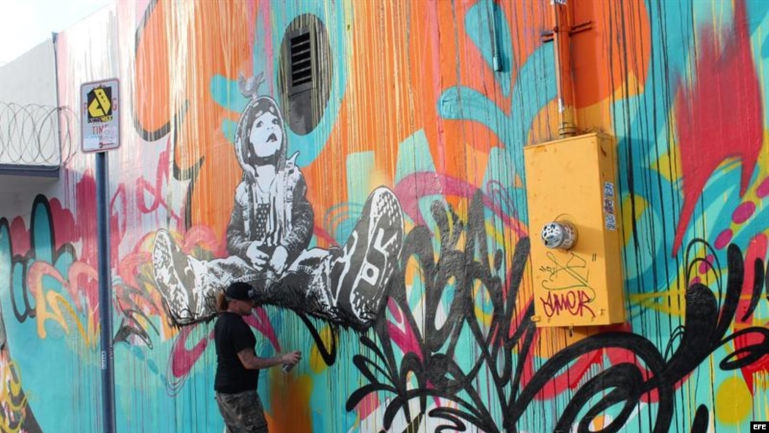 Un artista ultima detalles en un grafiti en Miami, Florida (EE.UU.). La zona de grafitis de Wynwood, el barrio artístico de Miami, reafirmará a partir del miércoles su condición de referente de las nuevas corrientes plásticas.