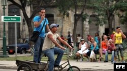 Dos hombres viajan en un triciclo por la zona colonial de La Habana (Cuba). 