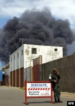 Un miembro de la Guardia Nacional vigila hoy, lunes 27 de agosto de 2012, los alrededores de la refinería de Amuay, que continúa ardiendo, en el Estado Falcón, Venezuela.