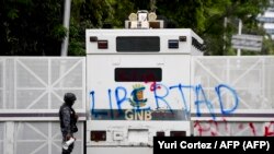 Policía observa expresiones escritas en la Universidad Central de Venezuela en una protesta el 14 de noviembre de 2019. (Yuri Cortez/AFP).