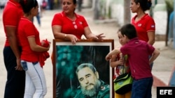  Un grupo de personas llevan un cuadro con la imagen de Fidel Catro mientras esperan la llegada de la caravana que traslada sus cenizas. (Archivo)