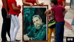 Un grupo de personas lleva un cuadro con la imagen de Fidel Catro en una calle de Holguín, a la espera de la caravana con las cenizas de Fidel Castro.