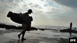 Archivo. Un pescador se dirige hacia el mar con sus utensilios de trabajo en una de las costas del litoral norte habanero. 