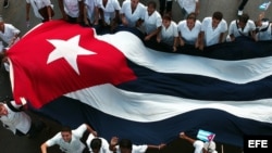 Estudiantes de medicina sostienen una bandera cubana durante una marcha en La Habana. Foto archivo.