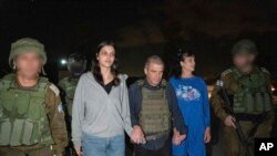 Judith Raanan (derecha) y su hija de 17 años de edad, Natalie, son escoltadas por soldados israelíes mientras vuelven a Israel, el viernes 20 de octubre de 2023, luego de que Hamas las capturó.