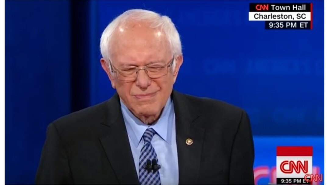 El gesto del senador Sanders al escuchar que el presentador cita una critica que se refería a Fidel Castro como un "dictador asesino".