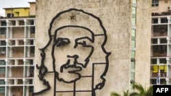 Un hombre camina frente al edificio del Ministerio del Interior con la imagen de Ernesto "Che" Guevara.