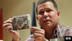 Omar Rodríguez, uno de los periodistas cubanos que han sido excarcelados y expatriados a España por el Gobierno de la isla, muestra un recorte de una revista durante una rueda de prensa en Madrid. 