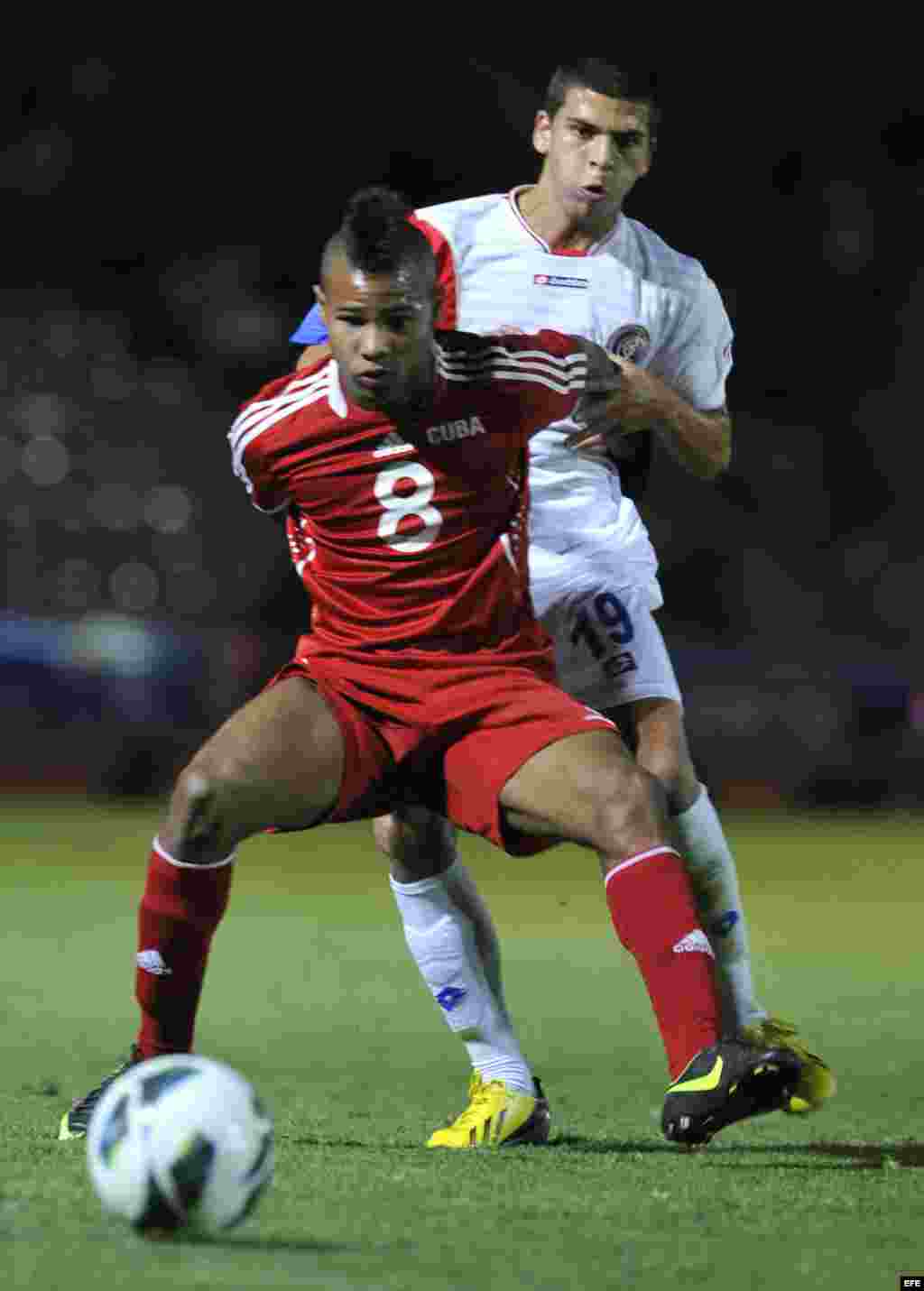 El jugador de Cuba Yordan Santa Cruz (frente) disputa el balón con Jean Carlo Agüero (atrás) de Costa Rica martes 26 de febrero de 2013, durante el partido de cuartos de final de la eliminatoria de la Concacaf para el Mundial Sub'20 de Turquía en el Esta