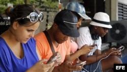 Jóvenes navegan por internet desde sus dispositivos móviles en una de las zonas habilitadas con Wi-fi en La Habana (julio, 2015). 