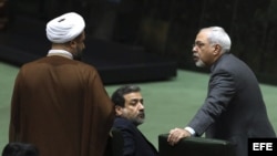 El ministro iraní de Asuntos Exteriores, Javad Zarif (dcha), conversa con un diputado mientras participa en la sesión parlamentaria convocada para hablar del acuerdo nuclear en Teherán, Irán