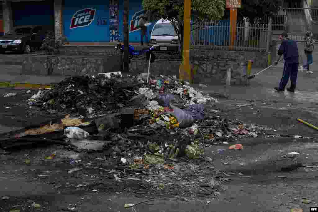 Una persona barre basura hoy, jueves 20 de febrero de 2014, luego de una protesta contra el gobierno del presidente Nicolás Maduro en la avenida Rómulo Gallegos del municipio Sucre en Caracas (Venezuela).