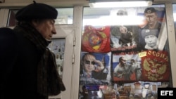 Un hombre observa varias sudaderas con la imagen del presidente de Rusia, Vladimir Putin, que se muestran en un escaparate de una tienda en Moscú, Rusia.