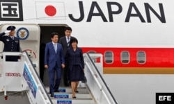 Shinzo Abe desciende de un avión con su esposa Akie.