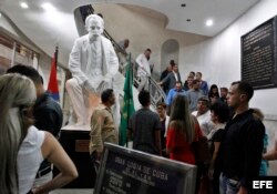 Varias personas pasando junto a una escultura del Héroe Nacional cubano José Martí, en una actividad pública para celebrar el 158 aniversario de la entrada de la masonería en Cuba.