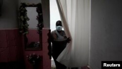 Una cubana se protege con una mascarilla del coronavirus. REUTERS/Alexandre Meneghini
