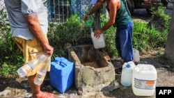 Un cubano llena contenedores de agua en Consolación del Sur en Pinar del Río. FOTO AFP/Yamil Lage.