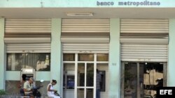 HAB13. LA HABANA (CUBA), 24/11/2011.- Ciudadanos sacan dinero en los cajeros automáticos de un banco hoy, jueves 24 de noviembre de 2011, en La Habana (Cuba). El emergente sector privado de Cuba y los campesinos de la isla, entre otros, podrán acceder des