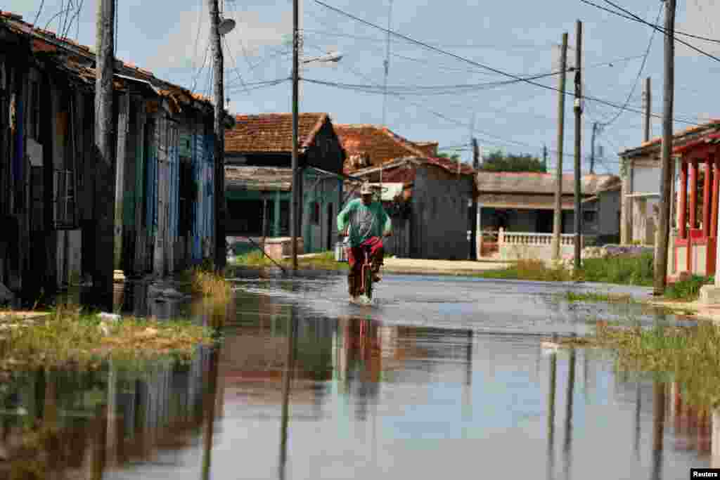 Un hombre atraviesa una calle inundada por la penetración del mar, en Batabanó, al paso del huracán Milton por la costa norte occidental de Cuba. REUTERS/Norlys Perez