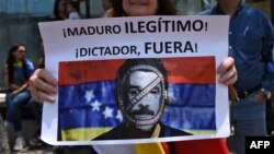 Una mujer sostiene un cartel contra nicolás Maduro durante una marcha frente a la embajada de Venezuela en Ciudad Guatemala.