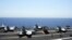 Miembros de la Marina guiando a varios aviones Hornet F/A 18 para su despegue desde la cubierta del portaaviones George H.W. Bush