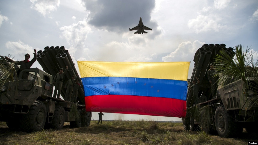 Un avión de combate Sukhoi Su-30MKV de la Fuerza Aérea de Venezuela, de fabricación rusa, ondea una bandera venezolana atada a lanzamisiles durante el ejercicio militar "Escudo Soberano 2015". (Archivo)