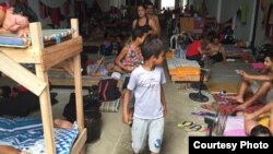 Niños en el almacén que sirve de refugio a los cubanos en Turbo, Colombia. Foto: R. Quintana.