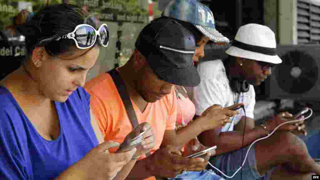 Un grupo de jóvenes navegan por internet desde dispositivos móviles hoy, viernes 3 de julio del 2015, en una de las zonas habilitadas con Wi-Fi en La Habana.
