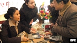 ARCHIVO. Kong Dongmei (izq) nieta de Mao Zedong, firma autógrafos durante la presentación de su libro Abrir el álbum de nuestra familia, Mi abuelo Mao Zedong en mi corazón. 