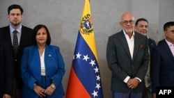 La jefa de la delegación opositora, Dinorah Figuera (segunda desde la izquierda), y el presidente de la Asamblea Nacional de Venezuela, Jorge Rodríguez (segundo desde la derecha).
